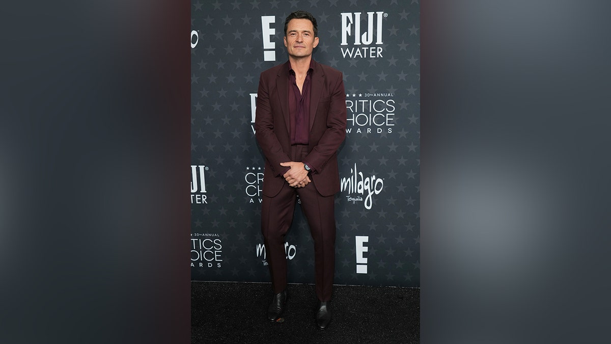 Orlando Bloom walked the red carpet in a burgundy suit.