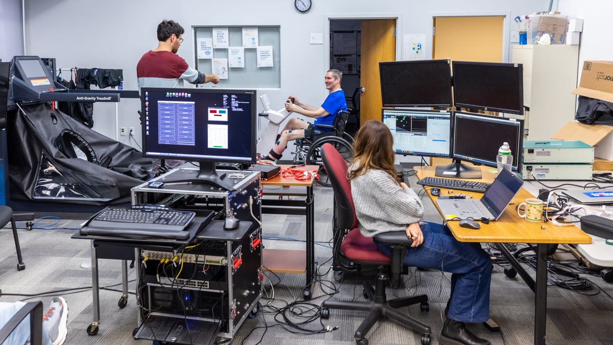 Researchers Genis Prat Ortega (left) and Serena Donadio (right) with the research participant Doug McCullough (center) during a testing session at the University of Pittsburgh.