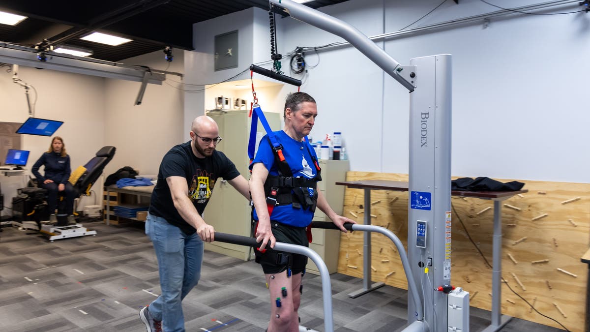 Graduate student Scott Ensel (left) assists research participant Doug McCullough during a testing session at the University of Pittsburgh.