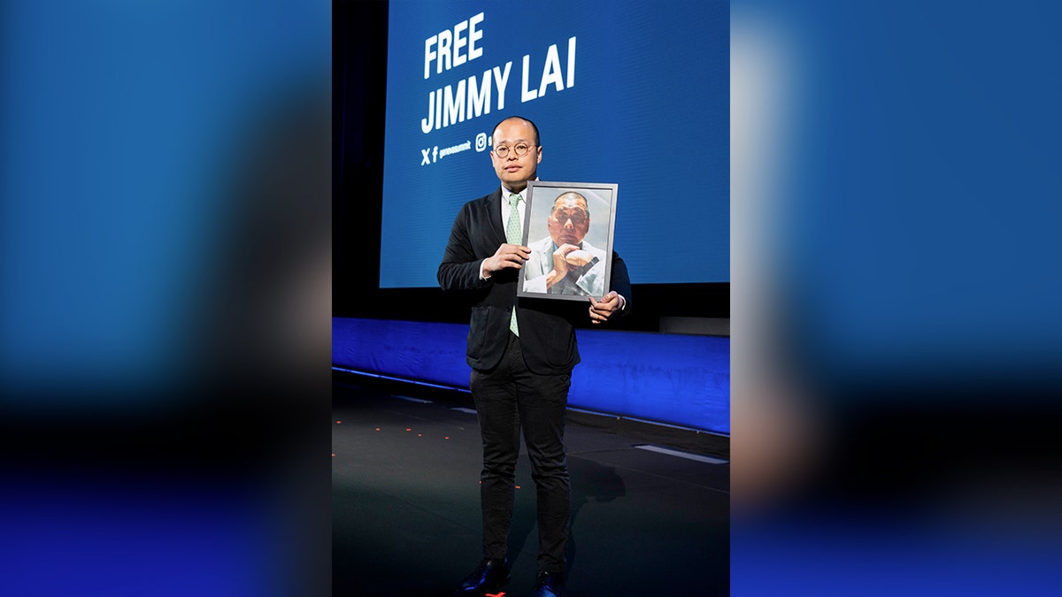 Sebastian Lay holds a picture of his father, the founder of Apple Daily Jimmy Lay