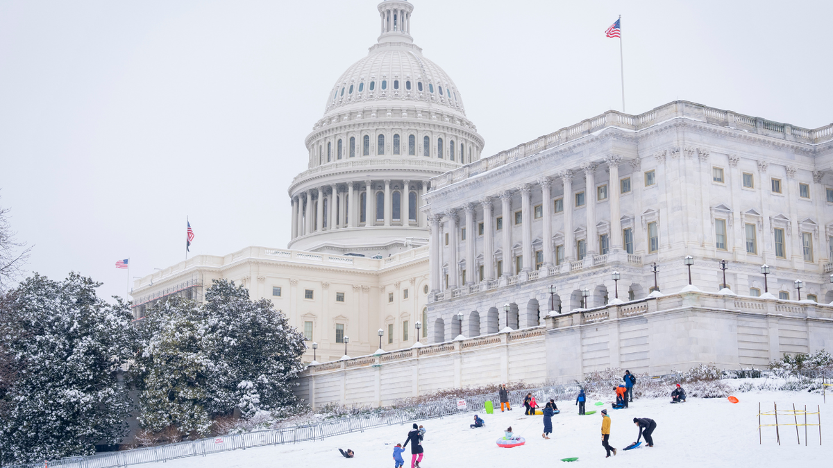 US Capitol and grounds covered in snow, kids on sleds