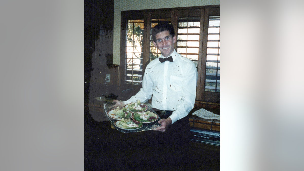 Terry Moogan holding a lot of dishes.