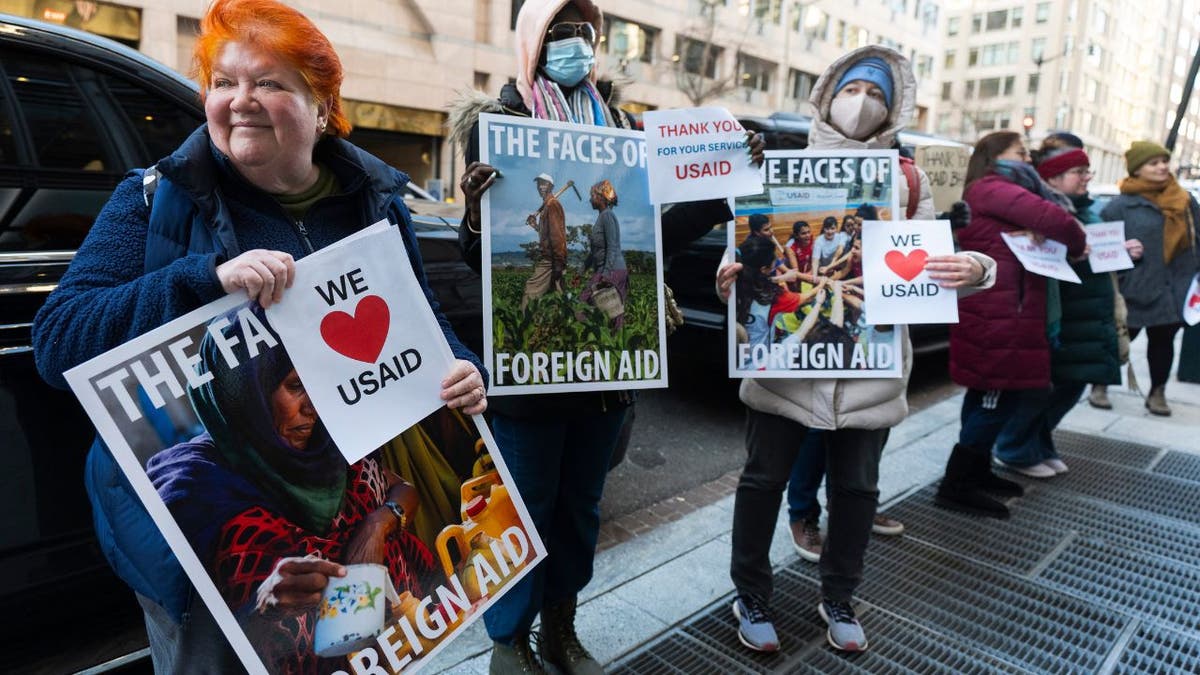 USAID supporters hold signs in protest of USAID cuts