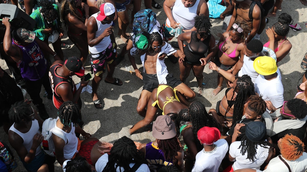 Spring breakers dance in a crowd on Saturday, April 20, 2024 during Orange Crush on Tybee Island.