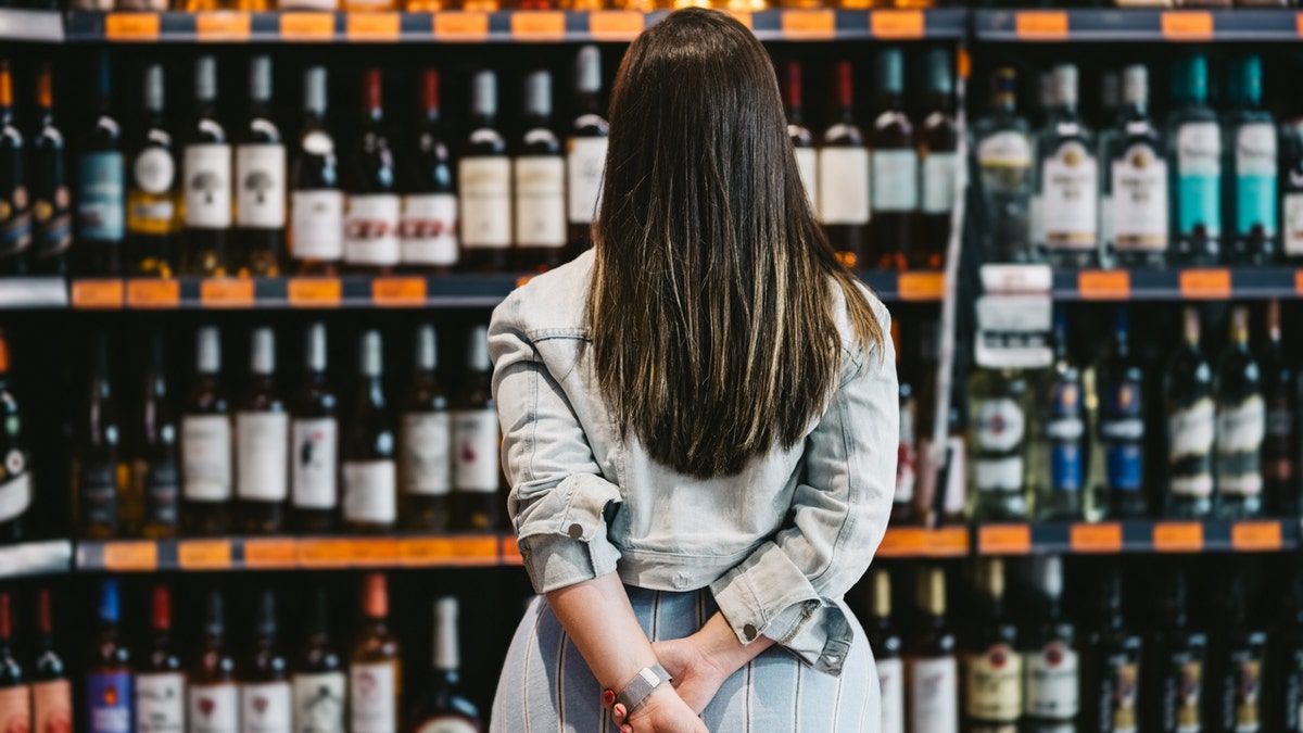A woman browsing wine in a store.