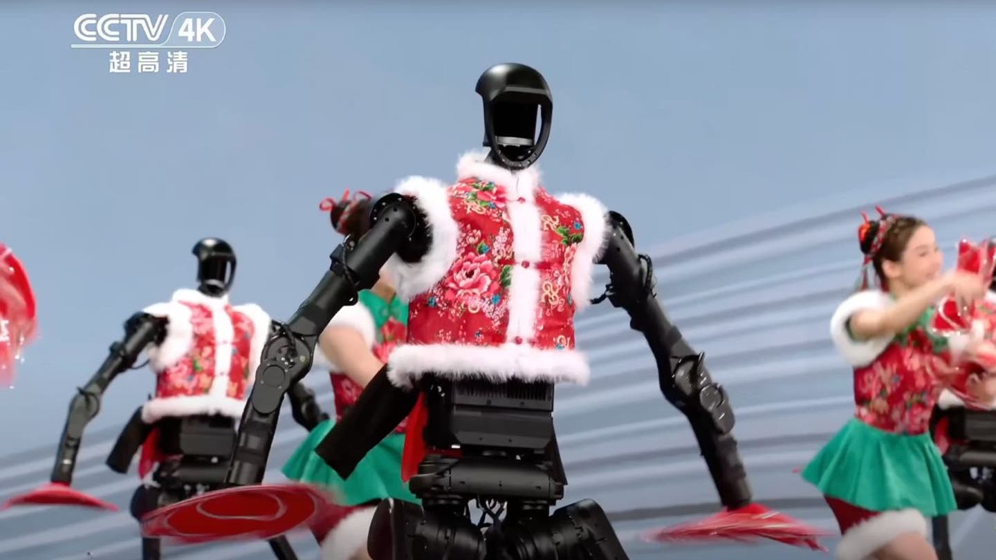 2 humanoid robots bust dance moves alongside humans