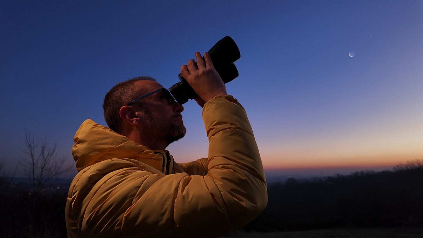 man looking through binoculars