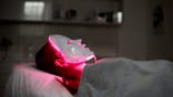 Person in red light therapy mask.