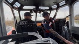 Two men in a U.S. Coast Guard patrolling the Rio Grande