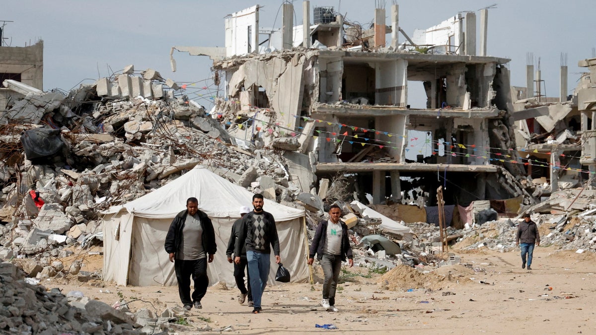 Palestinians walk in rubble of Rafah, Gaza 