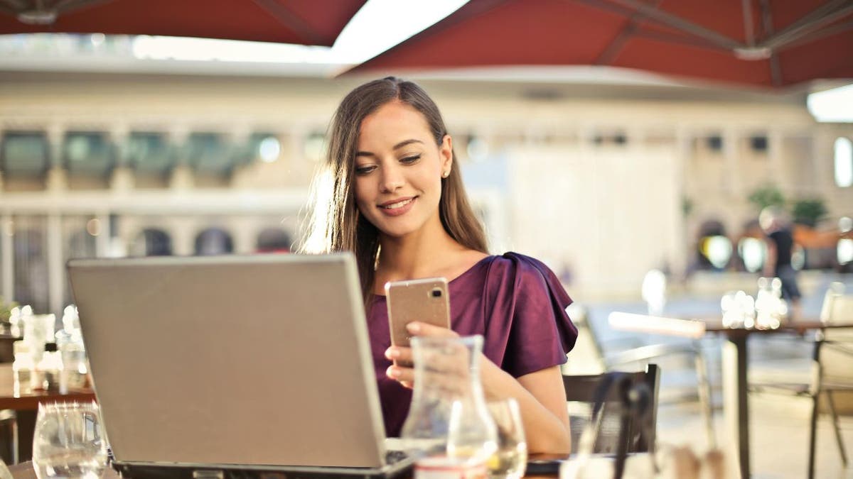 A woman with computer and phone