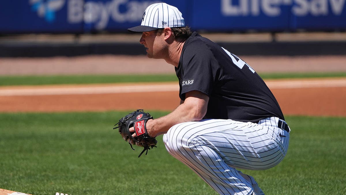 Gerrit Cole squats by mound