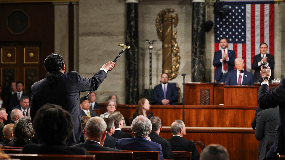 Rep. Al Green aponta para sua bengala em direção a Trump