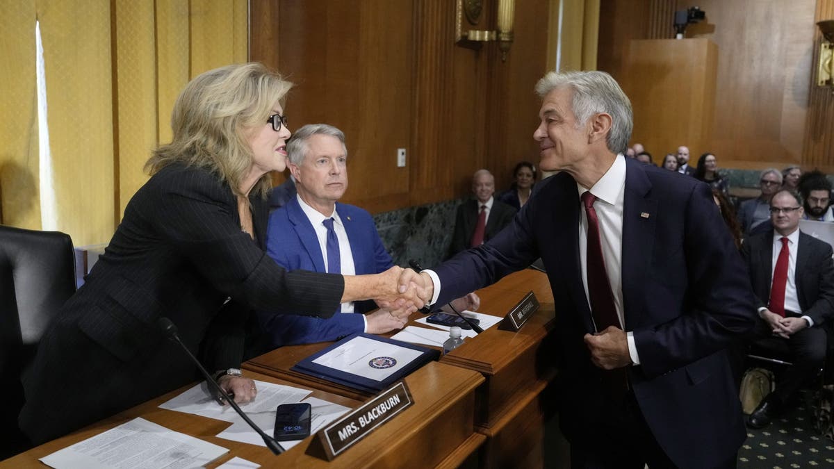 Dr. Mehmet Oz, President Donald Trump's pick to lead the Centers for Medicare and Medicaid Services, greets Sen. Marsha Blackburn, R-Tenn., as Sen. Roger Marshall, R-Kan., looks on before Oz testifies at his confirmation hearing before the Senate Finance Committee, on Capitol Hill Friday.