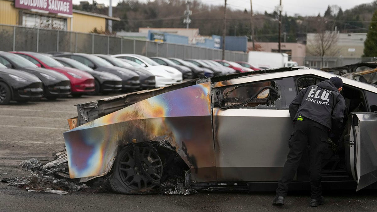 Seattle firefighters inspect a burned Tesla Cybertruck