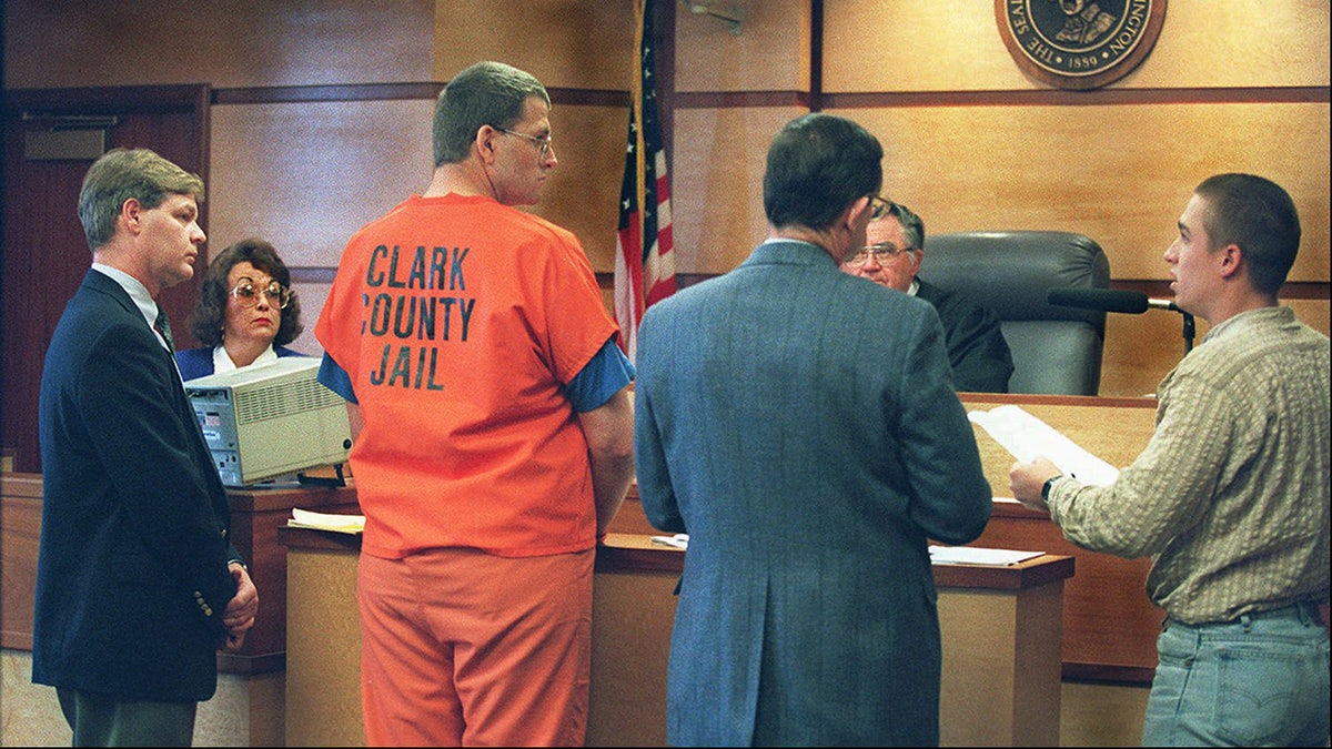 Keith Jesperson with his back turned wearing an orange jumpsuit in court.