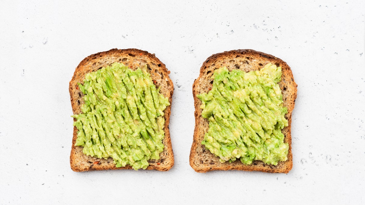 Una vista de mesa de tostadas de aguacate en pan de sándwich integral.