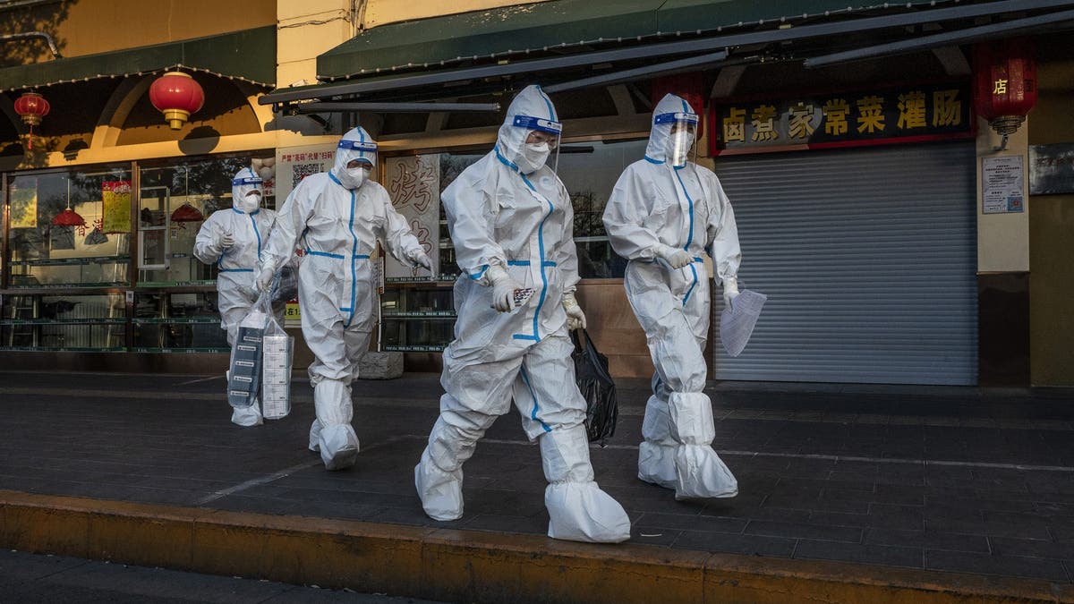 Chinese epidemische controlewerkers die PBM dragen in Beijing