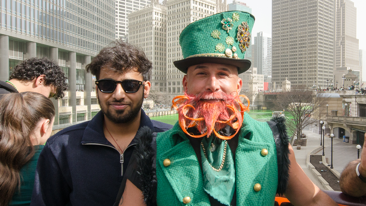 Chicago people and tourists take photos on the Chicago River during St. Patrick’s Day celebrations in Chicago, now in a vibrant green.