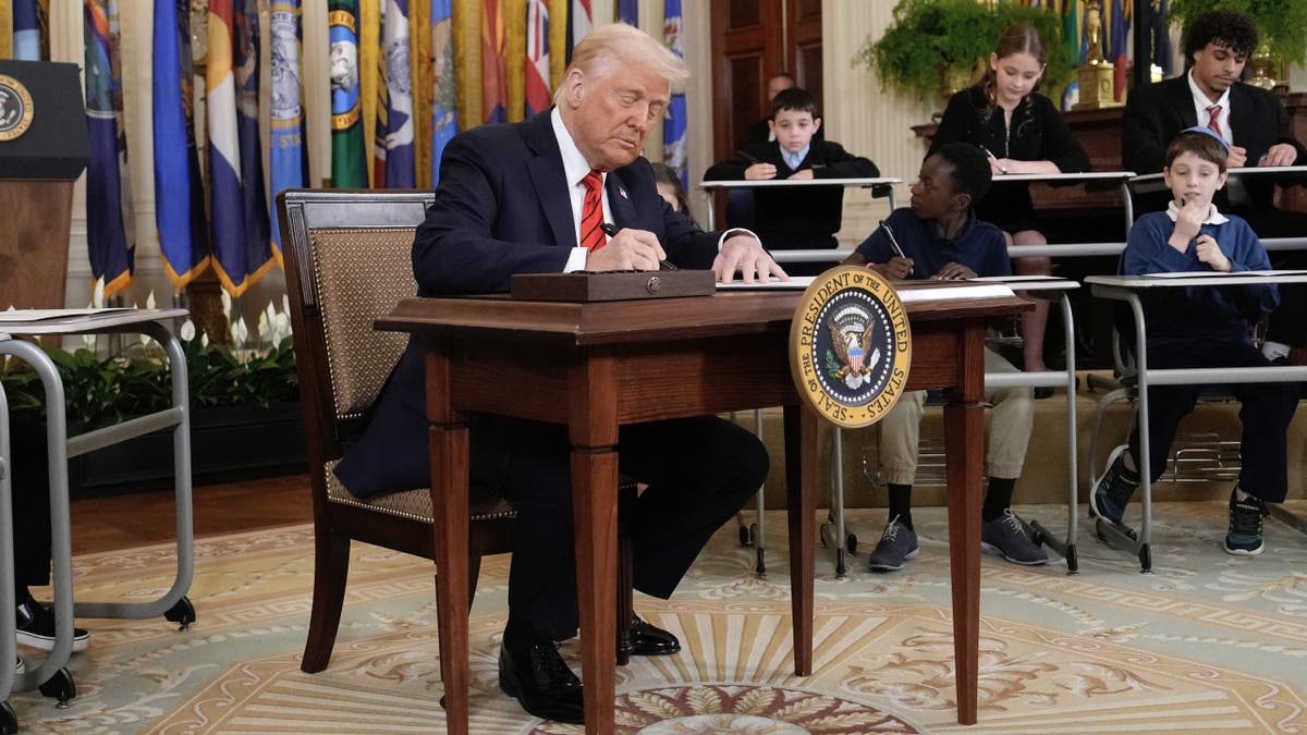 President Donald Trump signs an executive order in the East Room of the White House in Washington, Thursday, March 20, 2025.