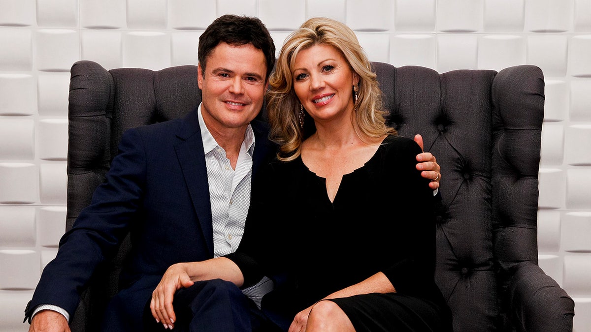 Donnie Osmond sits on the couch with his wife, Debbie