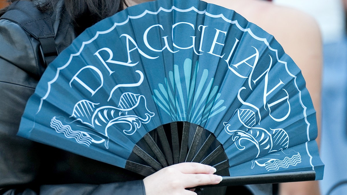 Person holds fan that says "DRAGGIELAND"