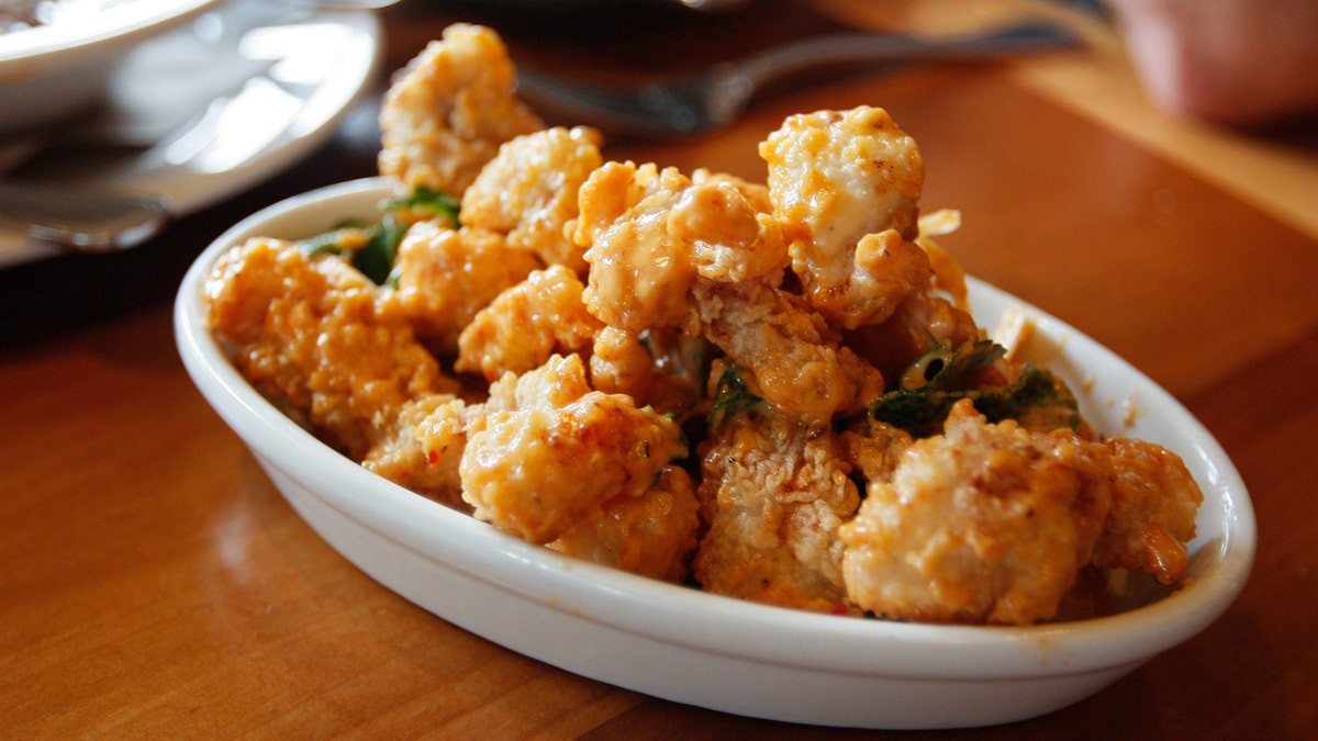 Freed crocodile meat appears in a plate on a table.