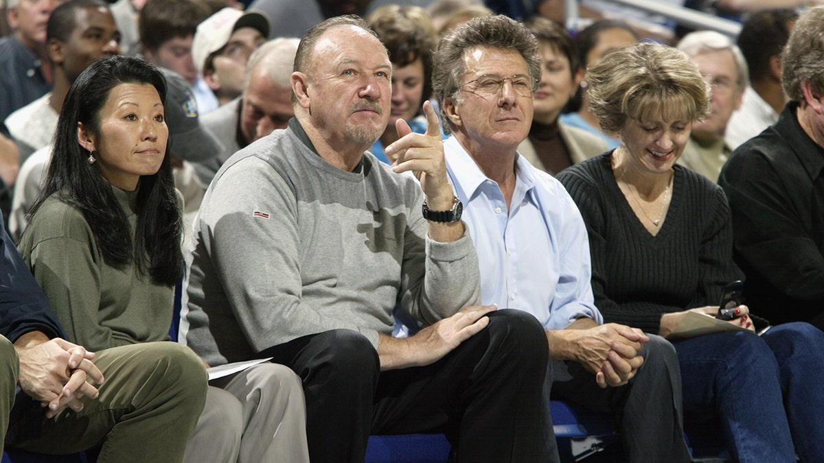 Gene Hackman and Dustin Hoffman sitting together at a basketball game