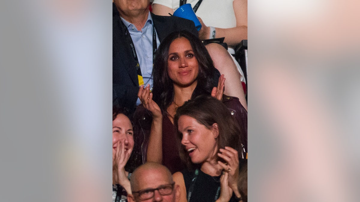 Meghan Markle applauding from a crowd.