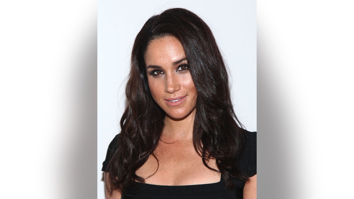 A close-up of Meghan Markle wearing a black dress.