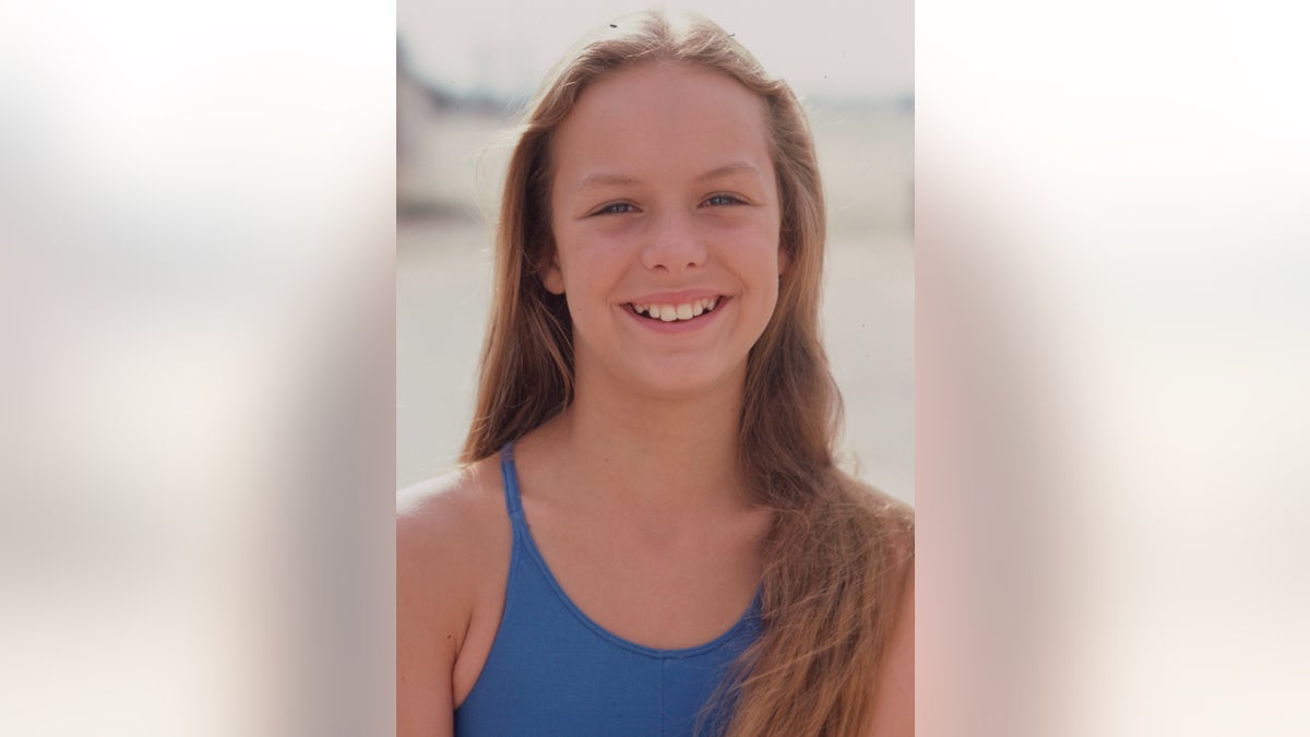 A young Melora Hardin wearing a blue swimsuit.