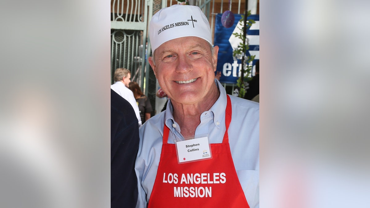 Steven Collins wearing a red apron and white shirt smiling.