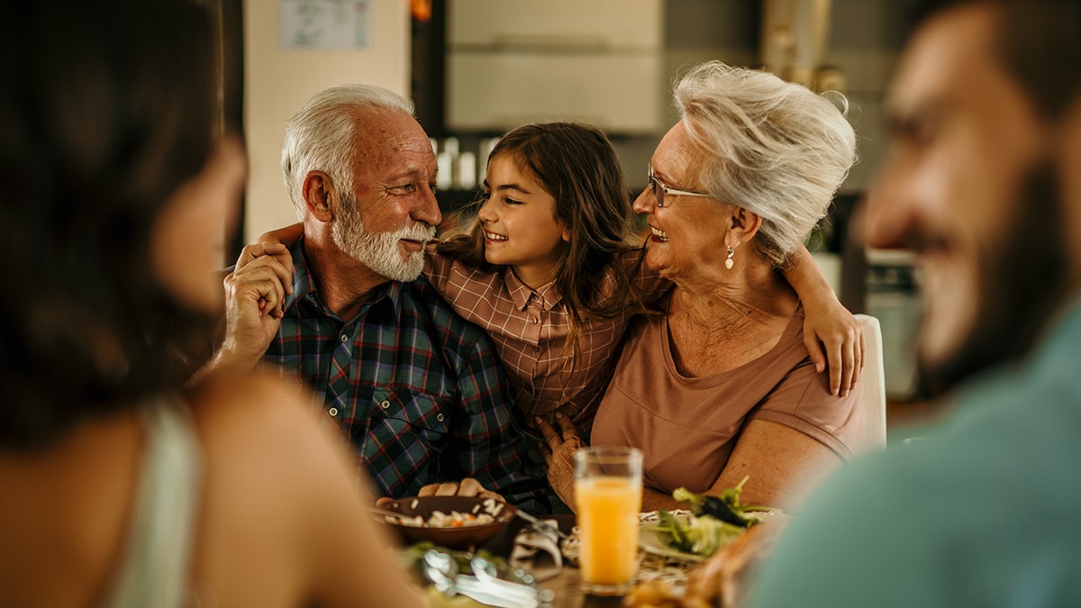 Little girl having dinner with grandparents