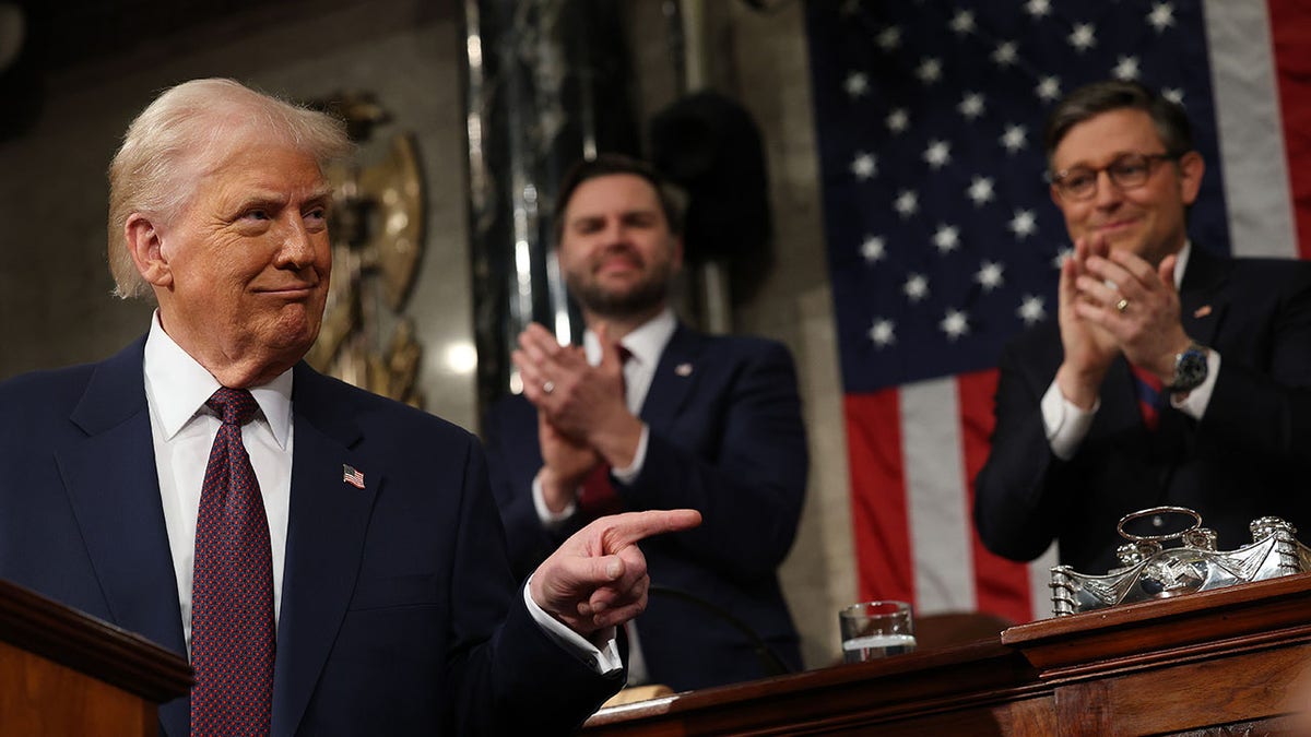 Trump points during congressional address with Vance and Johnson behind him