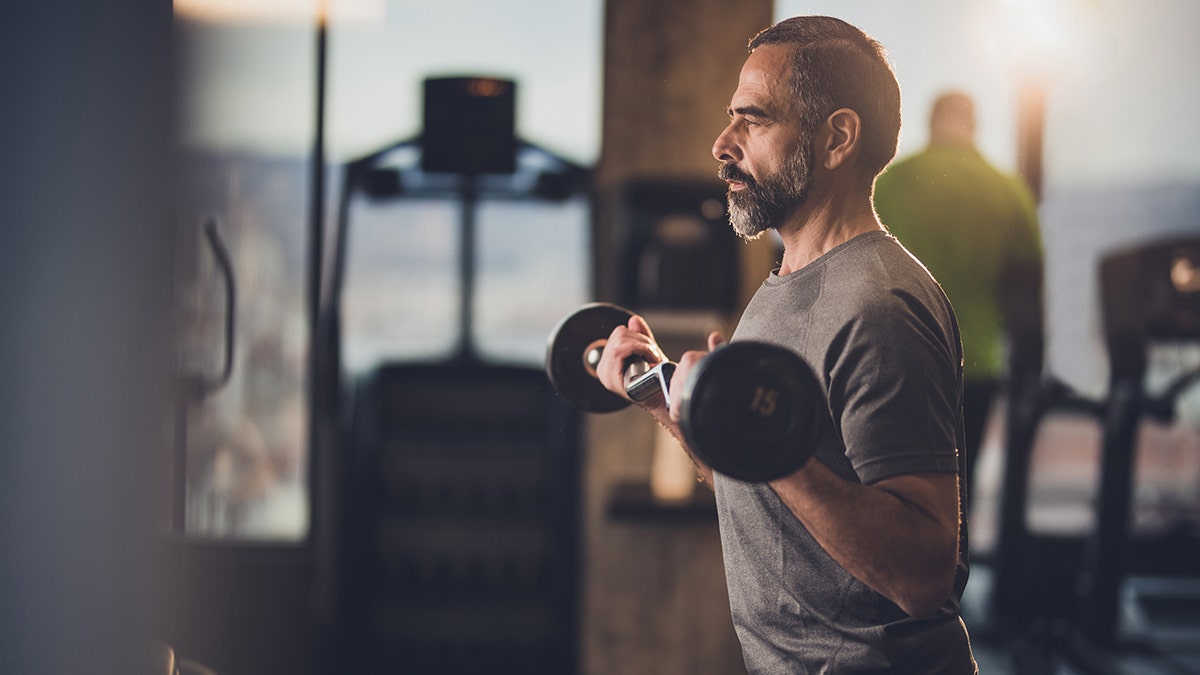 man exercising with barbell at the gym