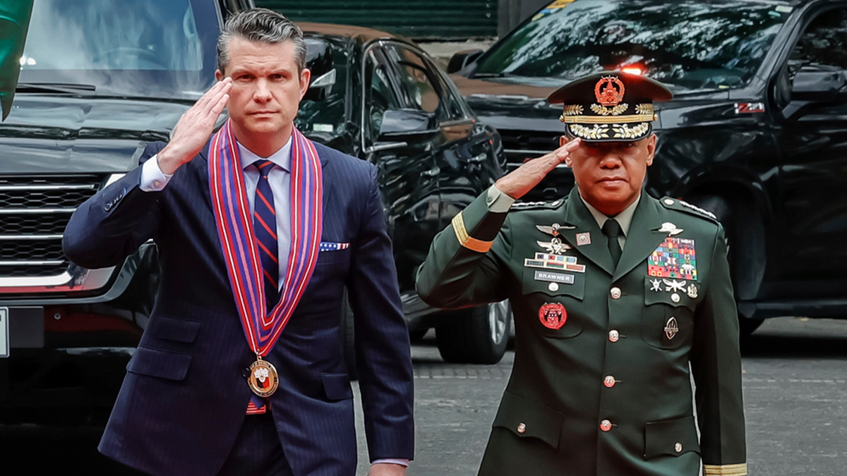 Hegseth saluting at troop review with Philippines military officer