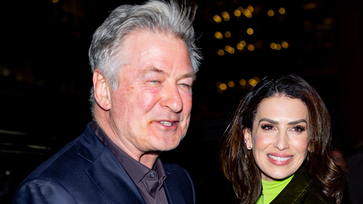 Alec Baldwin smiles next to wife Hilaria Baldwin.