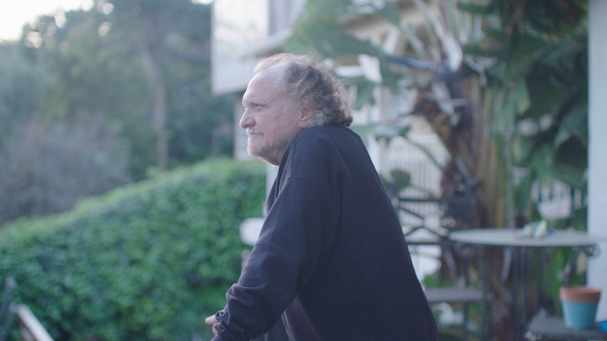 Tom Greene standing outside on his balcony.