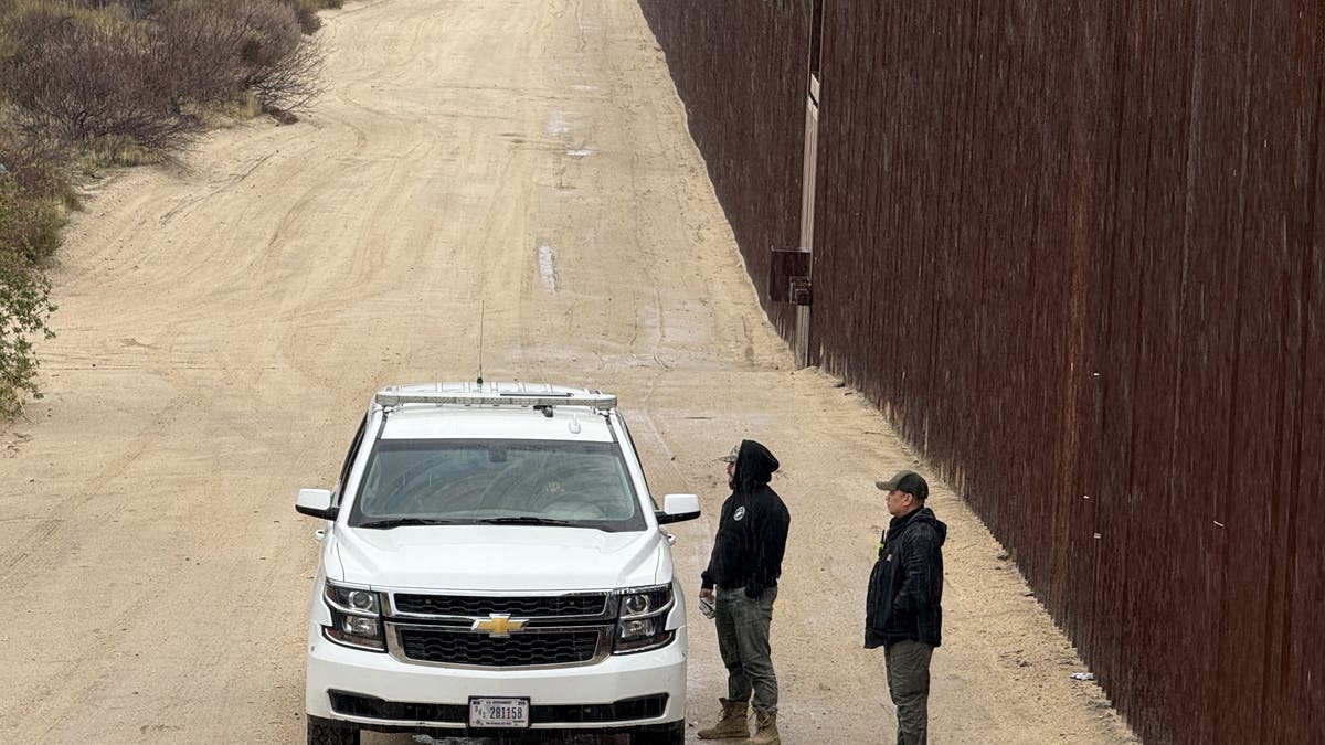 Border Vets chat with Border Patrol agent in SUV by border wall