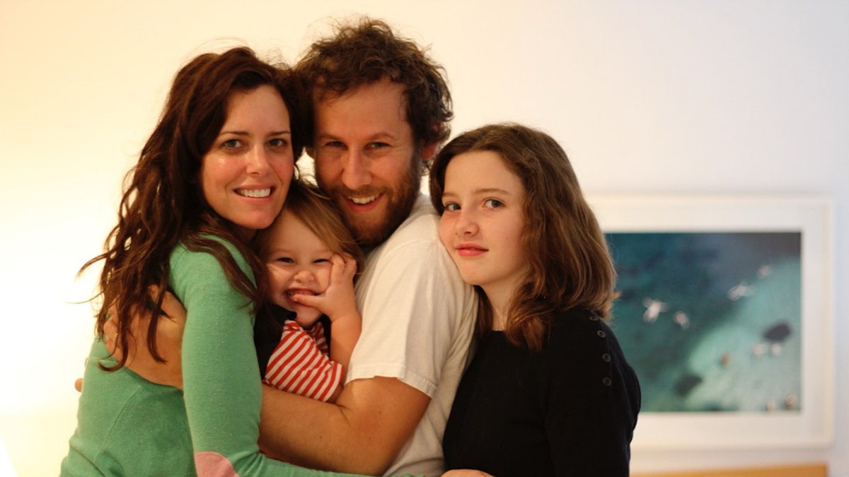 Ione Skye and her husband Ben Lee holding onto their two daughters.