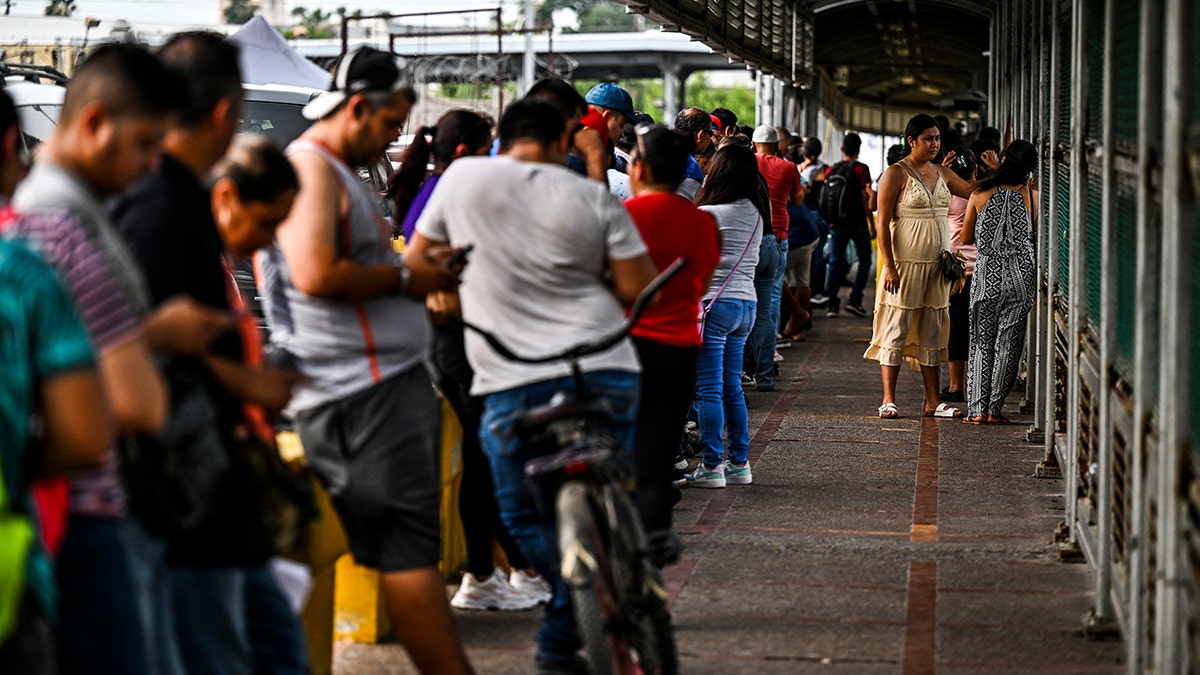 Migrants wait to enter the U.S.