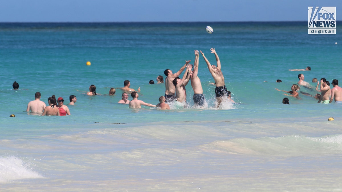 Spring breakers play in the water