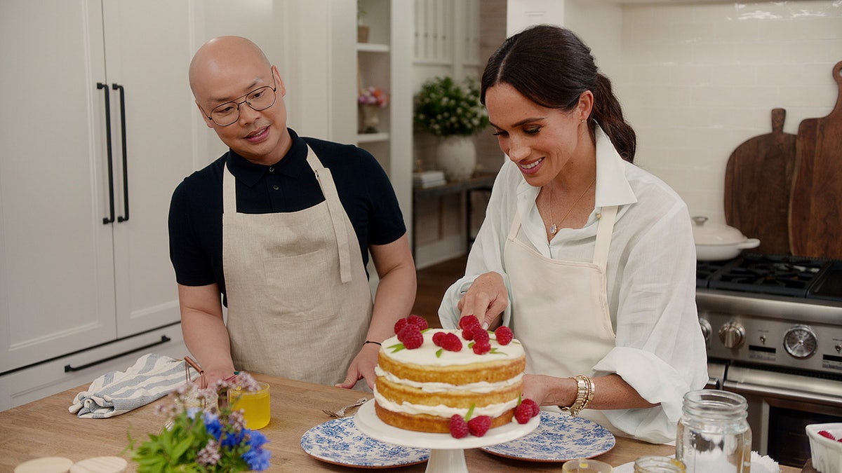Meghan Markle estaba arreglando un pastel dentro del edificio de Mantesito mientras miraba a su amigo.