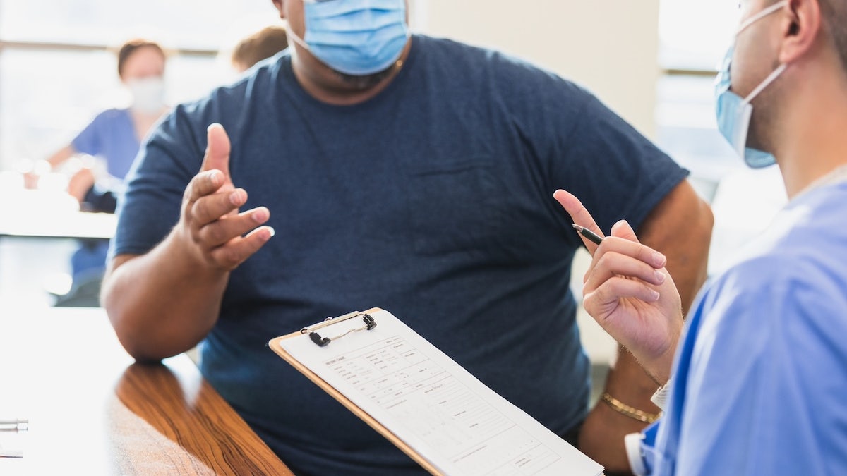 Obese man in mask at doctor