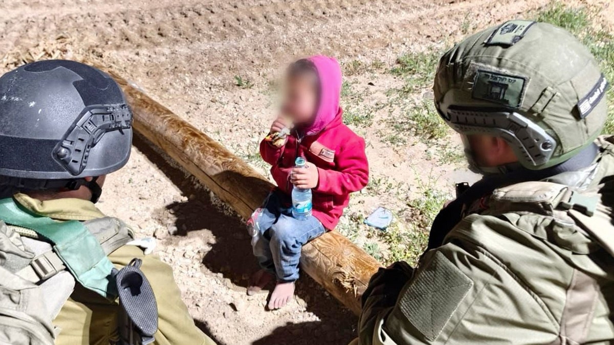 Los soldados israelíes hablan con un niño palestino