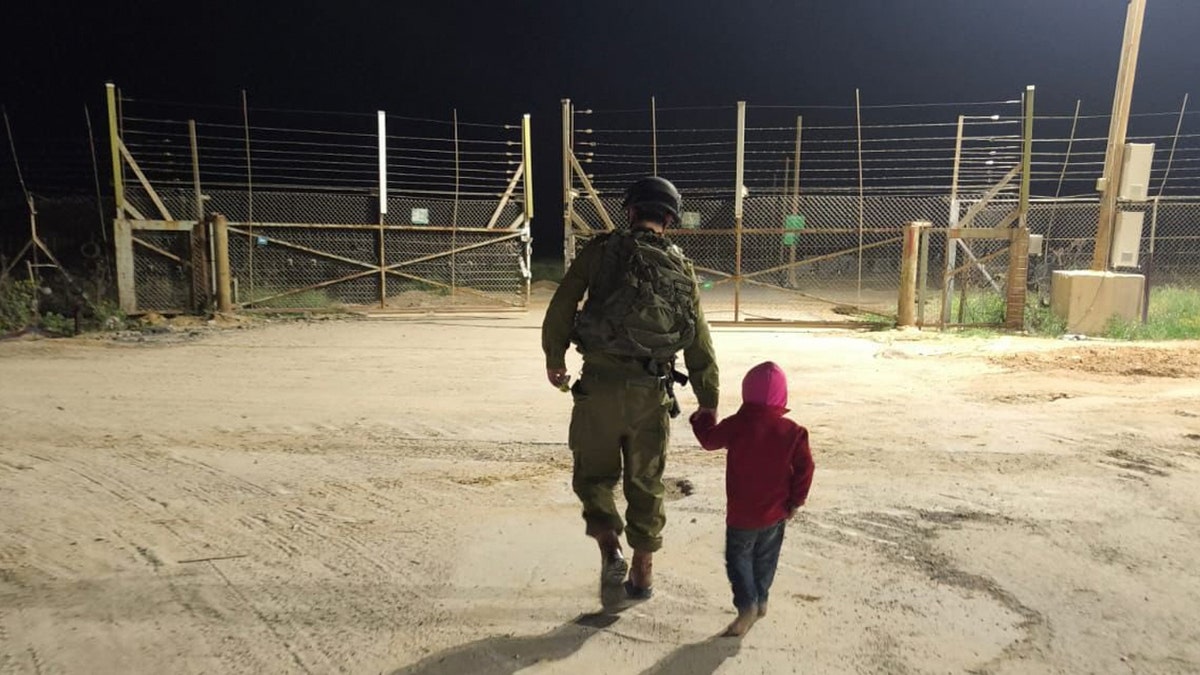 IDF Soldier runs a Palestinian child back