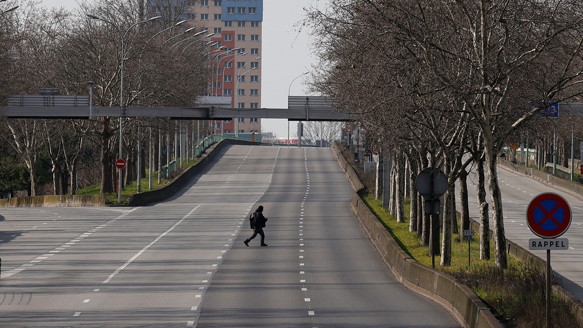 Person walks across empty Paris ring road