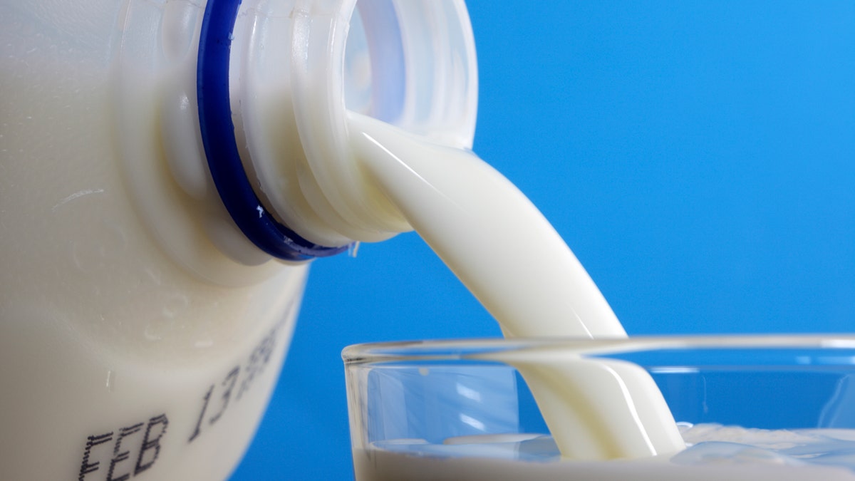 Milk is poured from a jug into a glass.