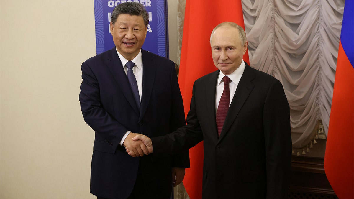 O presidente russo Putin e o presidente chinês Xi Jinping estão apertando as mãos.