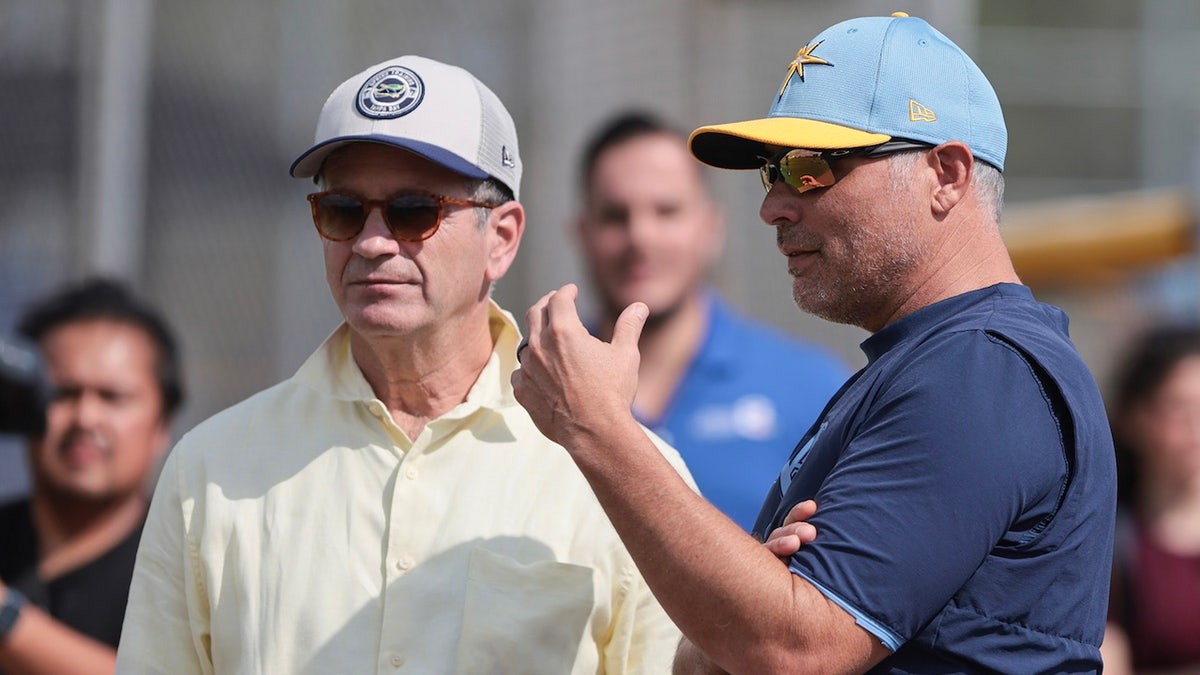Tampa Bay Rays principal owner Stuart Sternberg and Manager Kevin Cash watch as pitchers and catchers hold their first Spring Training workout in Port Charlotte, Florida, on February 12, 2025, at Charlotte Sports Park. Hurricane Milton rips the roof off Tropicana Field in St. Petersburg, Florida, where the Rays usually play their regular season games. They play their regular season home games this year at the New York Yankees Spring Training stadium, Steinbrenner Field, which seats 11,000 people.